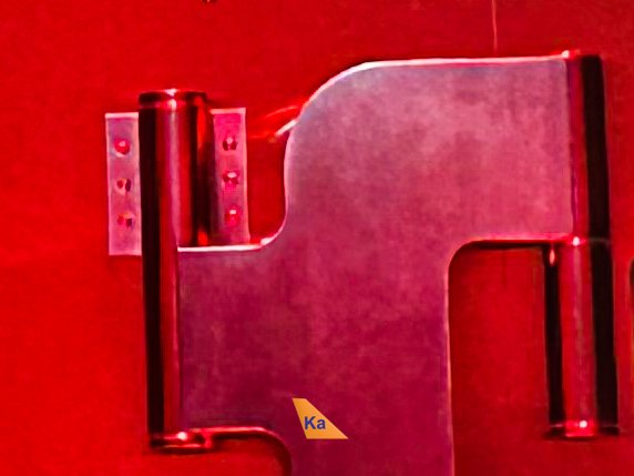 a metal hinge on a red wall