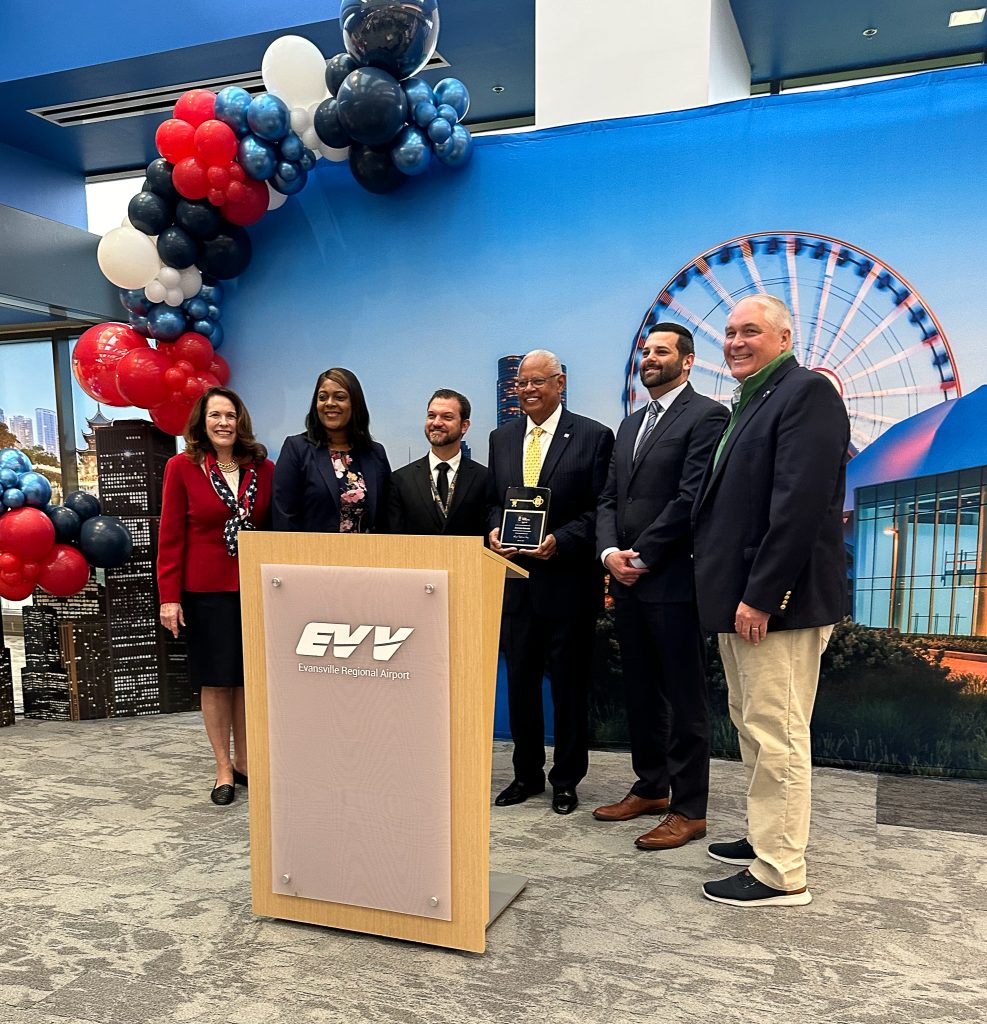 a group of people standing at a podium with balloons