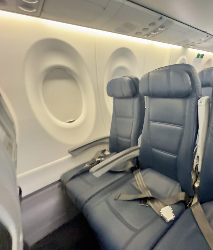 seats in an airplane with a white wall