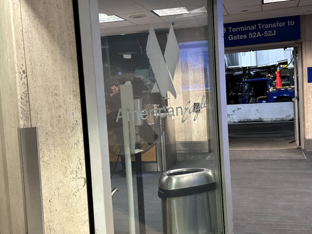 a window with a fan and trash can