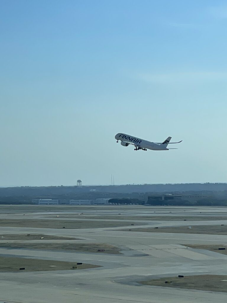 an airplane flying over a runway