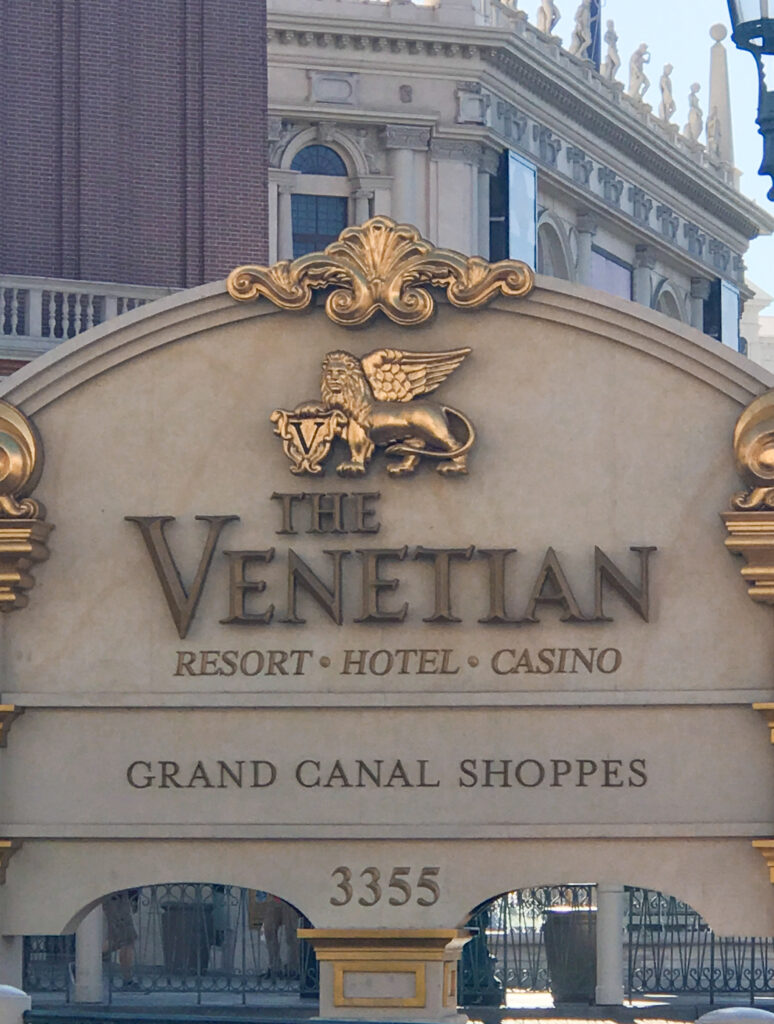 a sign with a lion and a building in the background